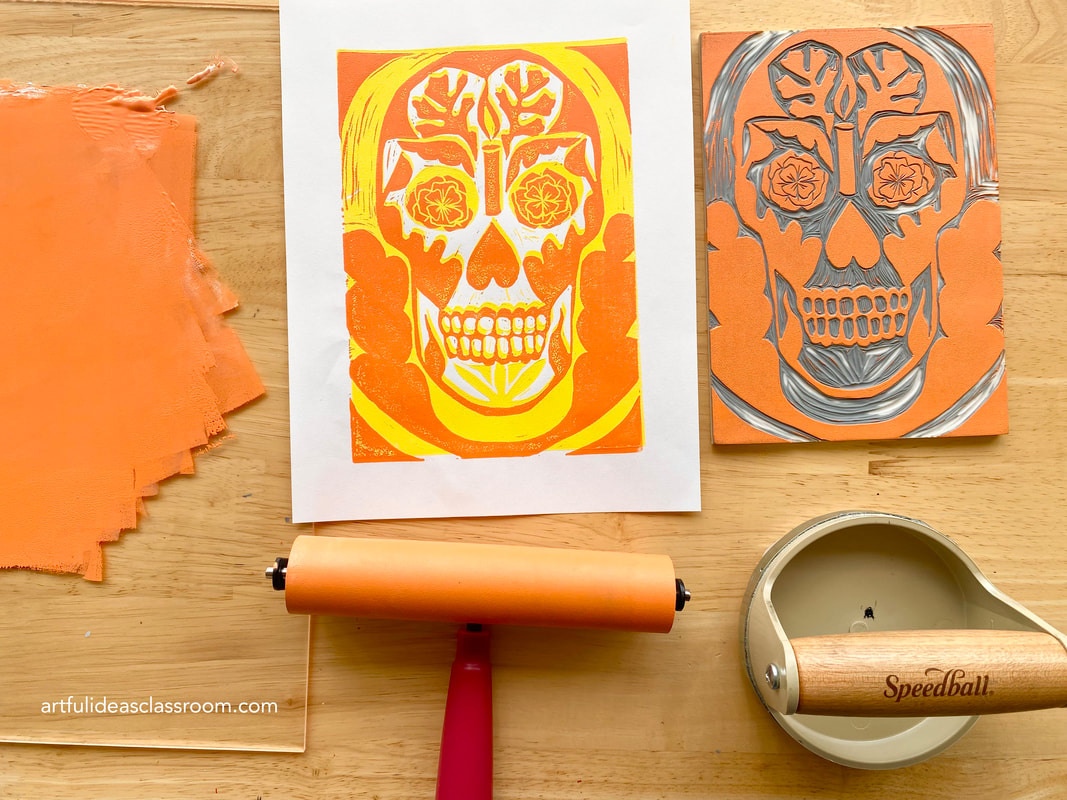 printmaking tools and a two color block print and carved printing block with the image of a calavera or skull image associated with Día de los Muertos