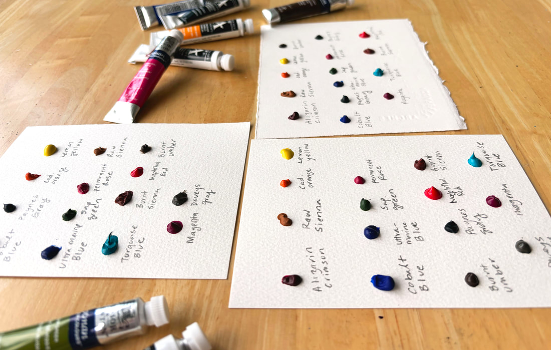 Handmade watercolor dot cards on a desk with tube watercolors